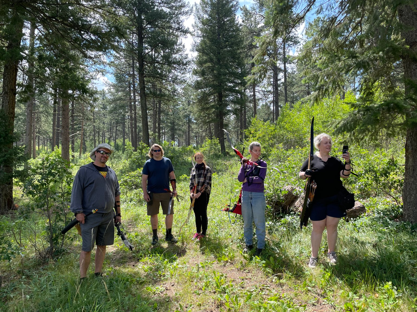 Group of archers in a sunlit forest clearing